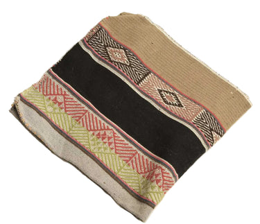 A square woven textile or rug sample with horizontal bands of tan, black, red, olive green, and beige geometric patterns, shown on a plain white background.