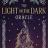 Book cover for 'The Light in the Dark Oracle' by Lucia Dami, featuring a dark purple celestial background with stars, moons, birds, and a kneeling figure with long flowing hair.
