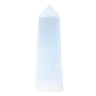 A natural white selenite crystal tower with a pointed tip, standing upright against a solid light blue background.