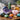 Assorted polished gemstones, amethyst cluster, and crystal points on a wooden surface.