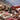 Shamanic ritual tools with stones, feathers, and herbs on a patterned textile in mountains.