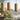 Three bamboo wind chimes hanging outdoors with a soft scenic landscape background.