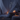 Burning incense stick with swirling smoke and lit ritual candles in a serene bedroom setting.