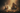A hooded figure sitting by a toy steam train on tracks amidst mystical fog and autumn leaves.