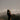 Woman practicing mindfulness and meditation against a mountain landscape at sunset.