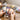 Hands holding celestial tarot and oracle cards on a wooden altar with crystals and a candle.