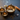 Three brass singing bowls with smoke from incense, crystals, and dried lavender on a dark surface.