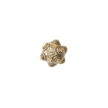 Hand-carved bone ritual tool with spiral and leaf engravings on a white background