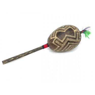Handcrafted wooden shamanic rattle with geometric carvings and colorful feathers.