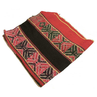 Handwoven red and black patterned ritual cloth with geometric tribal designs.