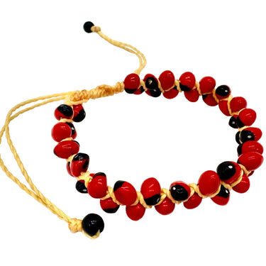 A beaded bracelet with alternating glossy red and black round beads, threaded on a light tan adjustable cord with sliding knots and small black end beads.