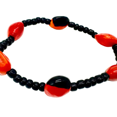 A beaded stretch bracelet featuring glossy black round beads and five large, polished red and black oval beads.