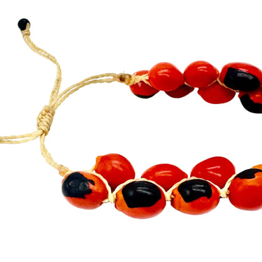 A beaded stretch bracelet featuring glossy red and black beads separated by natural tan jute cord.