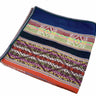 A folded square woven textile, likely a scarf or bandana, featuring a navy blue top section and a highly detailed, multicolored geometric patterned border with orange, green, red, yellow, and purple elements, set against a plain white background.