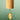A bamboo wind chime with a hanging wooden striker and black cord, shown against a soft green gradient background.